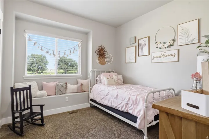 Built-in window bench, large window with blinds, light-toned walls, and carpet flooring