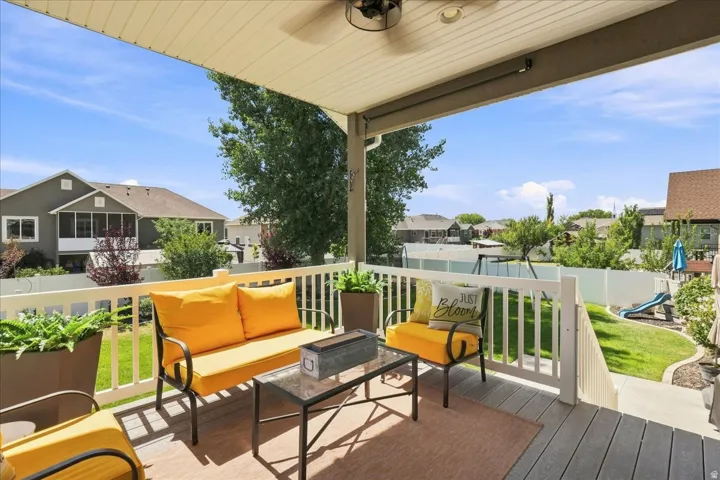 Covered composite deck with a ceiling fan, recessed lighting, and white railings