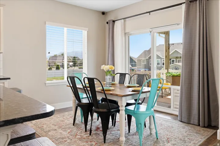 Dining area featuring a sliding glass door, a window with blinds, and wood-finish flooring