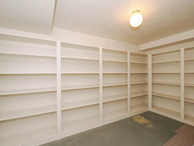Built-in shelving spanning multiple walls, integrated ceiling light fixture