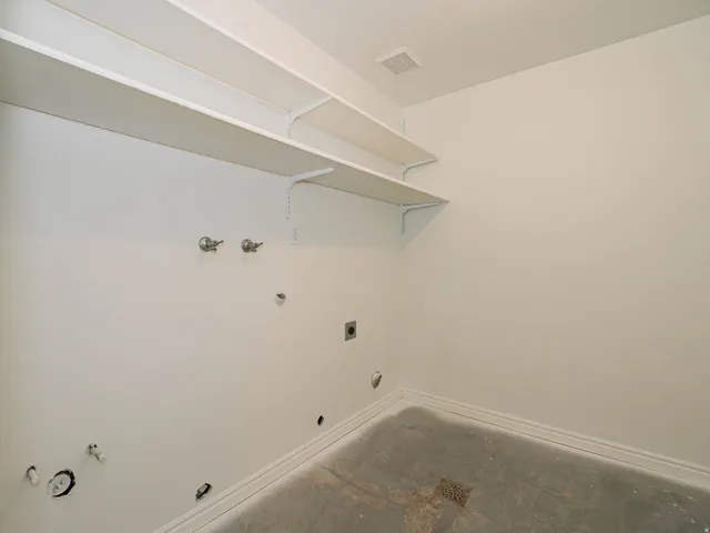 Built-in shelving for storage, pre-plumbed for appliances, and a durable concrete floor