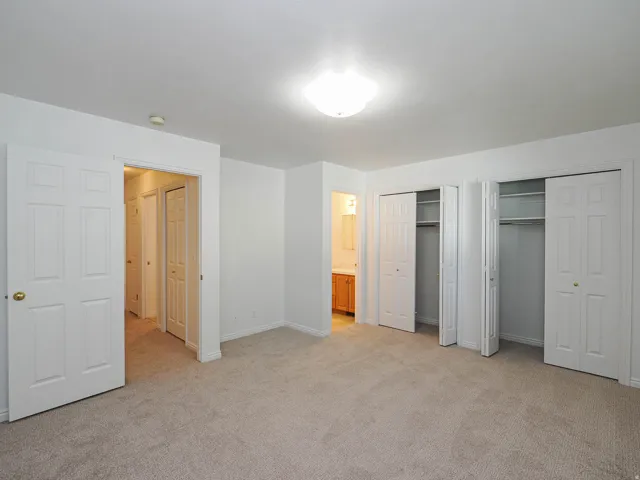Wall-to-wall carpeting, two bi-fold door closets, recessed lighting, and a white interior paint scheme
