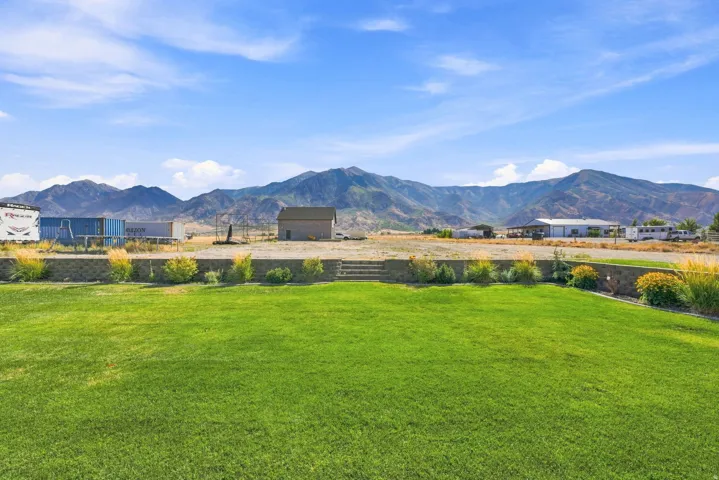 Expansive green lawn with a retaining wall and tiered landscaping