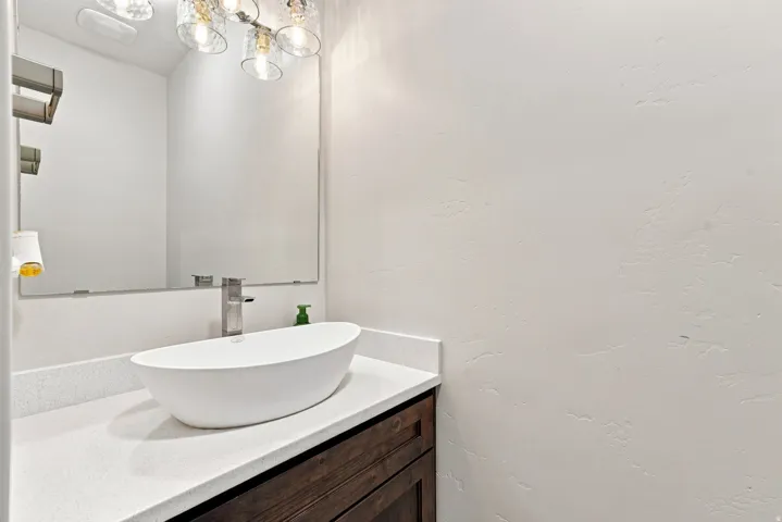 Modern vessel sink with a single-handle faucet, quartz countertop, and wood-finish cabinetry