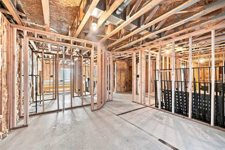 Unfinished basement with exposed wood framing, concrete flooring, and visible ceiling joists