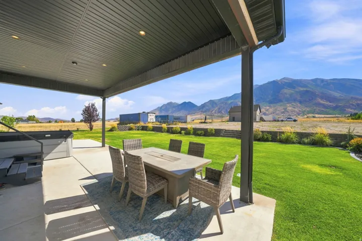 Covered patio with recessed lighting, concrete flooring, and an expansive lawn