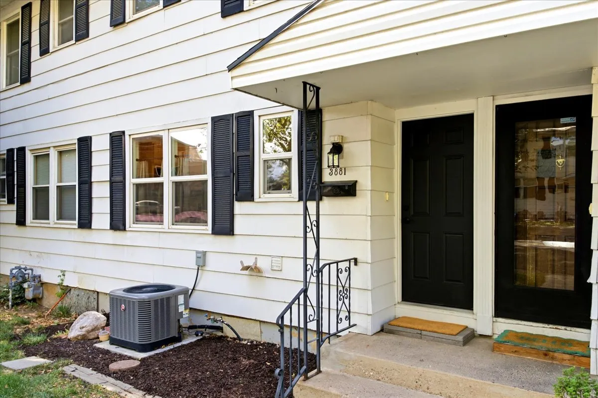 White siding exterior with black shutters and black entry door