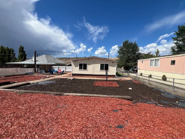 Expansive yard featuring red and dark mulch landscaping