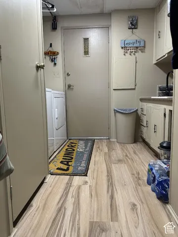 Wood-finish flooring, built-in cabinetry, integrated sink, and a full-size washer and dryer