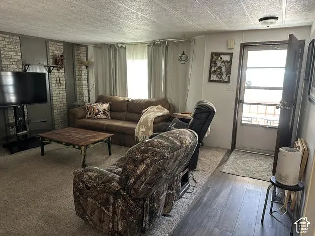 Textured ceiling panels, wood-finish flooring, and a panel door with a glass insert
