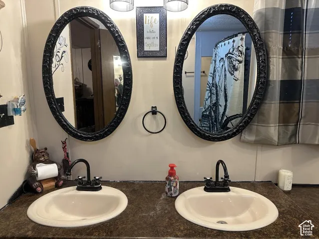 Dual vanity with integrated sinks, dark countertop, and black fixtures