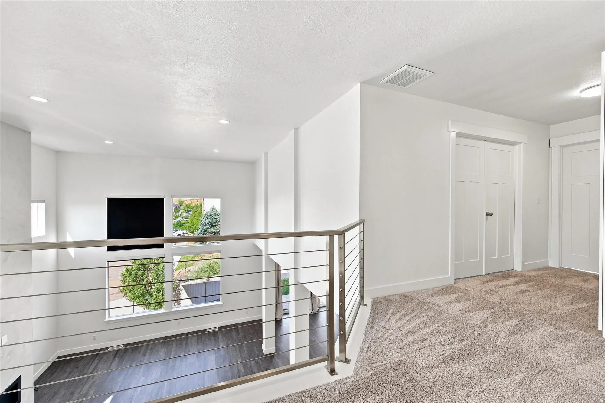 Open-concept space with high ceilings, recessed lighting, and large windows