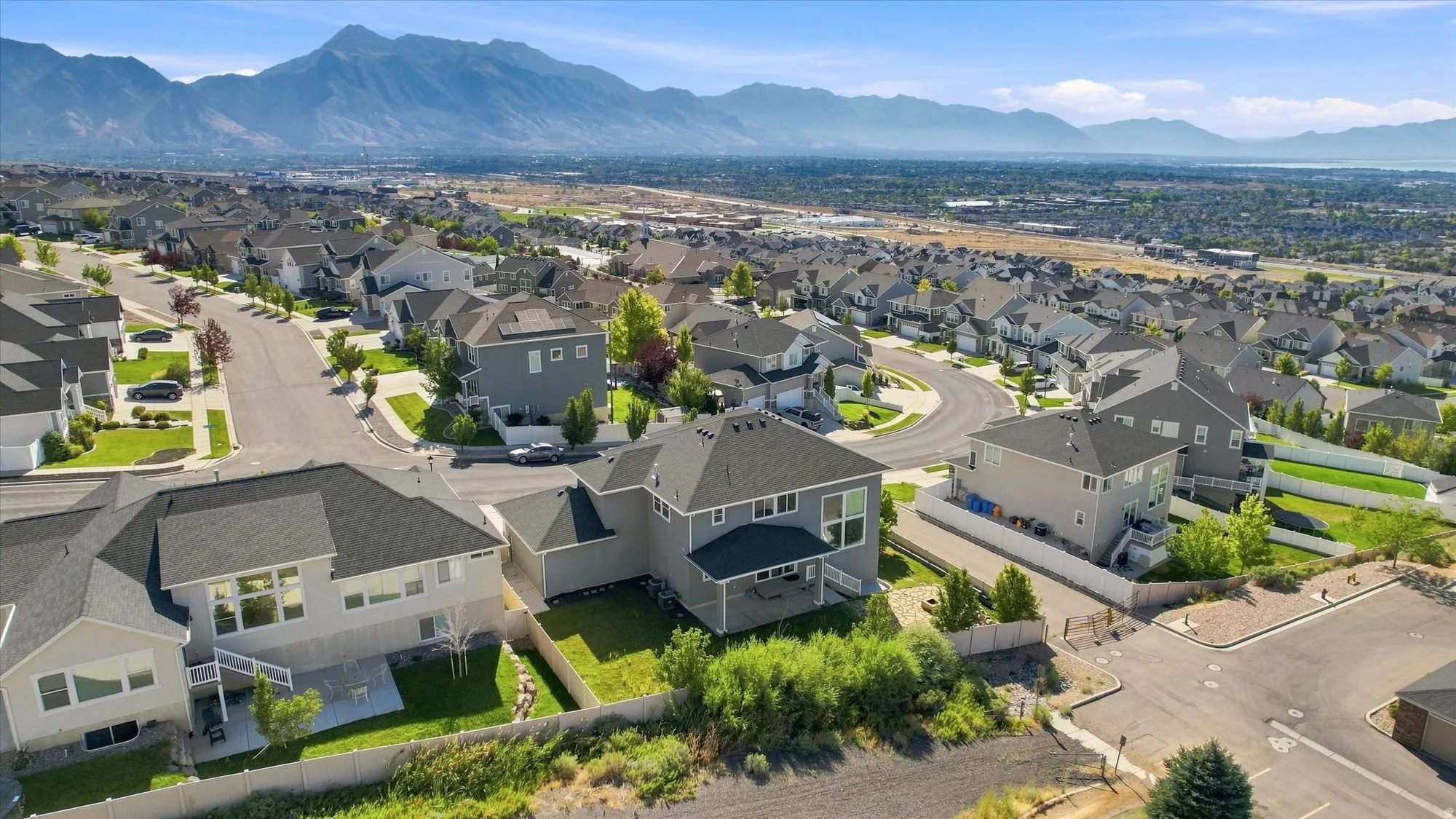 Residential neighborhood with uniform architecture, mountainous backdrop, and developed streets