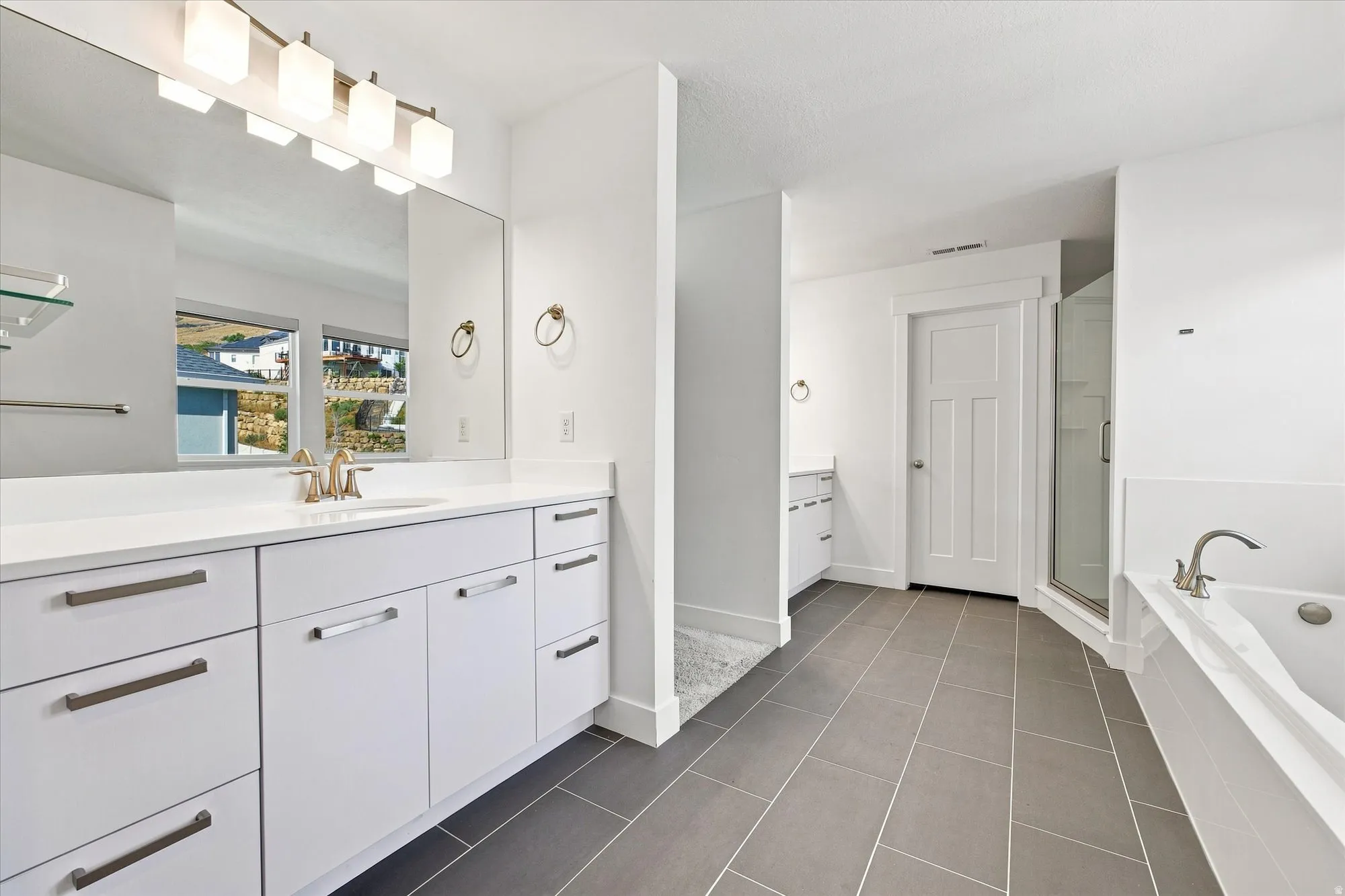 White vanity with extensive storage, countertop, and an undermount sink