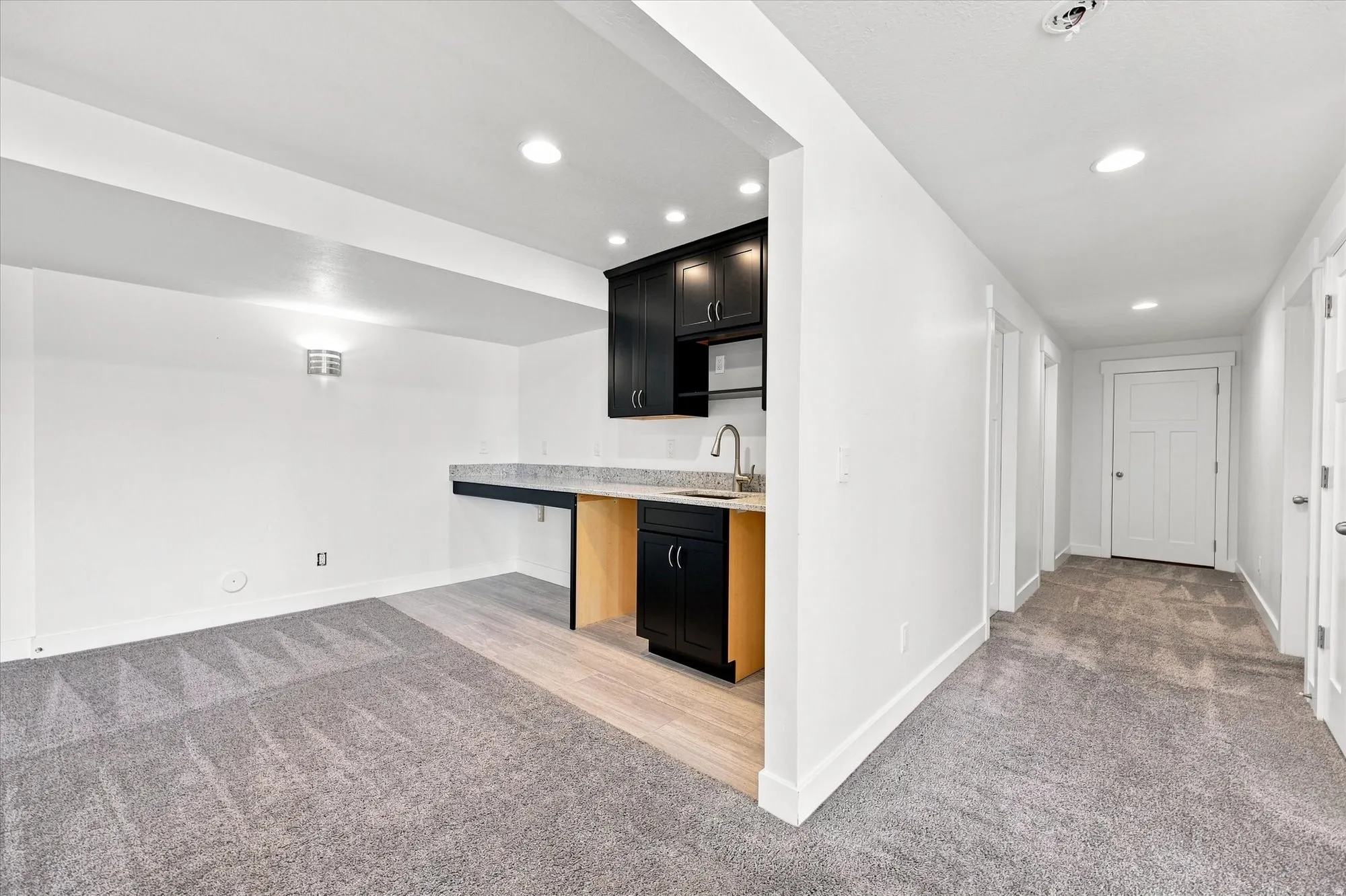 Built-in wet bar with dark cabinetry, integrated microwave, and a stainless steel faucet