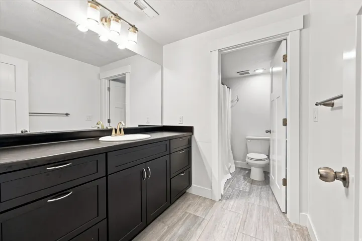 Dark wood-finish vanity with ample storage and stone-finish countertop