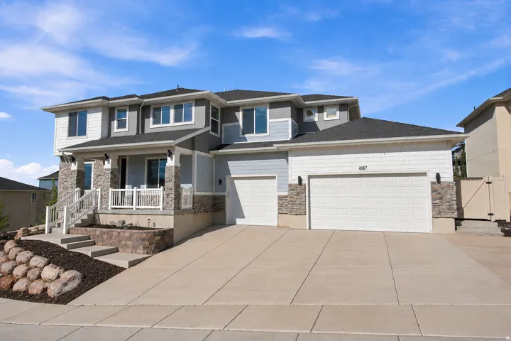 Multi-level facade with light blue siding and stone accents