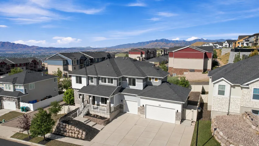 Two-story residence featuring a covered front porch, a two-car garage, and a single-car garage