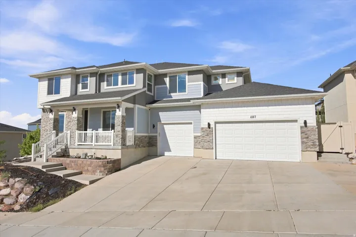 Multi-level facade with light blue siding and stone accents