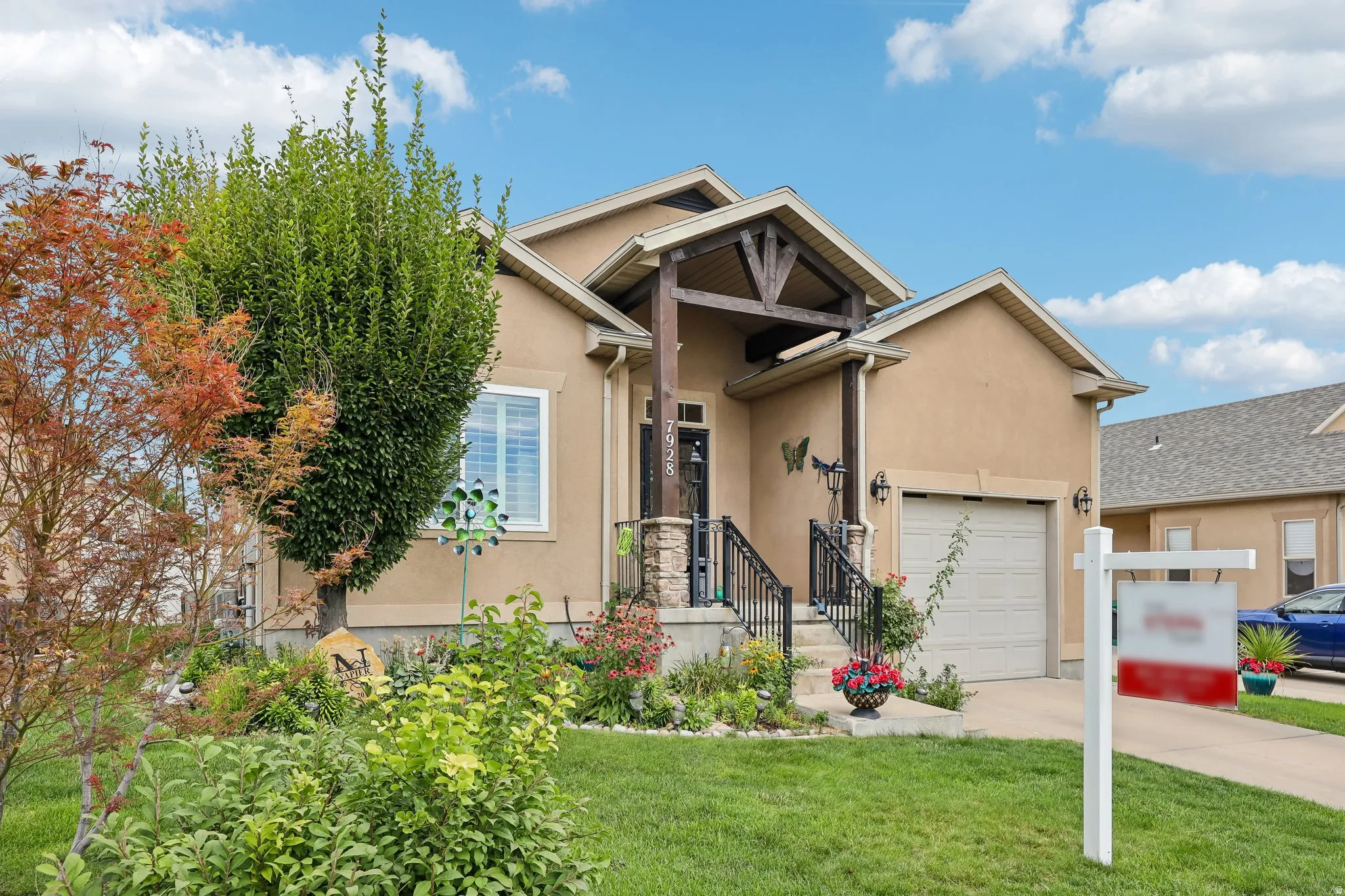 Stucco exterior with a prominent front porch, stone accents, and a wood-beam entryway