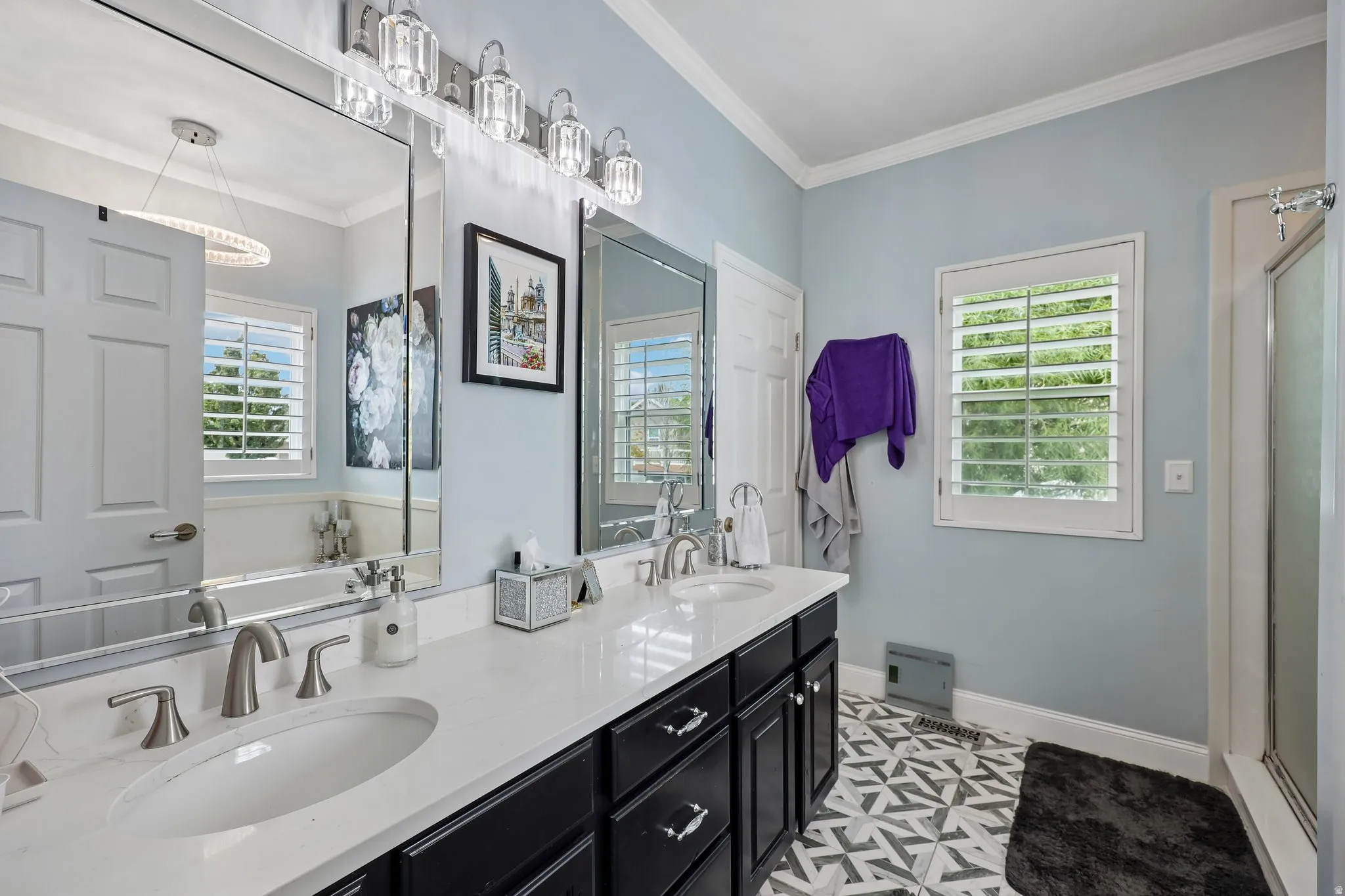 Dual vanity with undermount sinks and brushed nickel fixtures, white countertop, dark wood-finish cabinetry, and patterned tile flooring