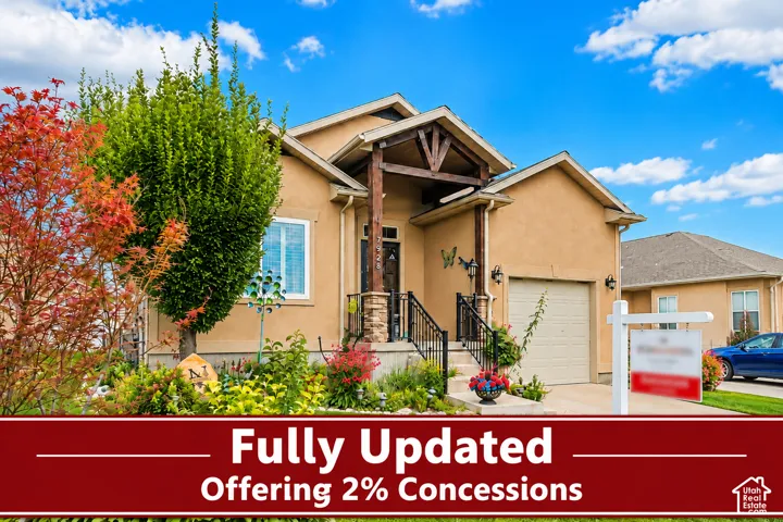 Stucco exterior with a covered entry, stone column accents, wood-beam details, a single garage, and established landscaping