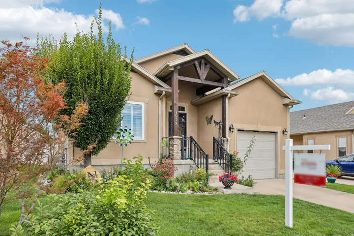 Stucco exterior with a prominent front porch, stone accents, and a wood-beam entryway