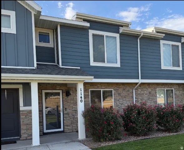 Multi-level facade featuring blue horizontal siding and stone veneer