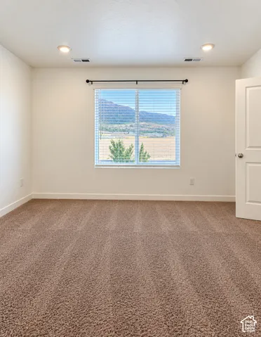 Primary Bedroom Recessed ceiling lighting, a window with horizontal blinds, tan carpet, and a white interior door