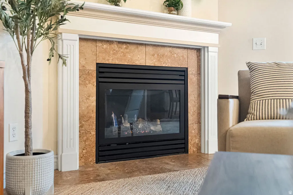 Elegant living room showcasing a wood-burning fireplace with black metal surround and cork-finish surround panels, framed by white trim molding