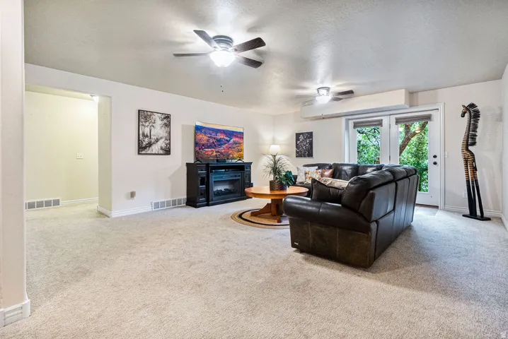 Spacious living area featuring light-toned carpeting and recessed lighting