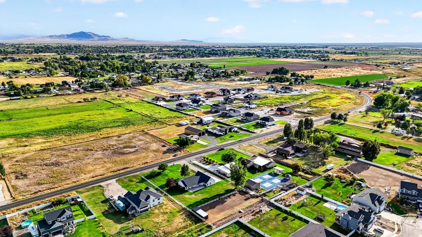 Expansive aerial perspective showcasing varied terrain, including cultivated fields and established residential areas