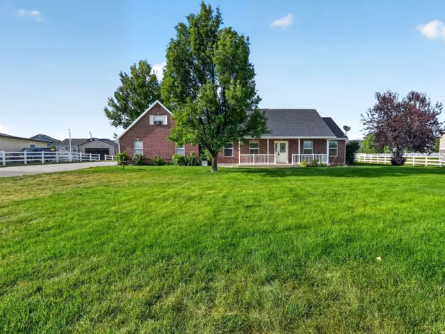 Red brick exterior with white trim, covered front porch, and gable roof