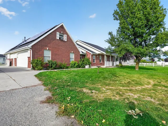 Brick exterior residence featuring a covered porch, white railing, and an attached two-car garage