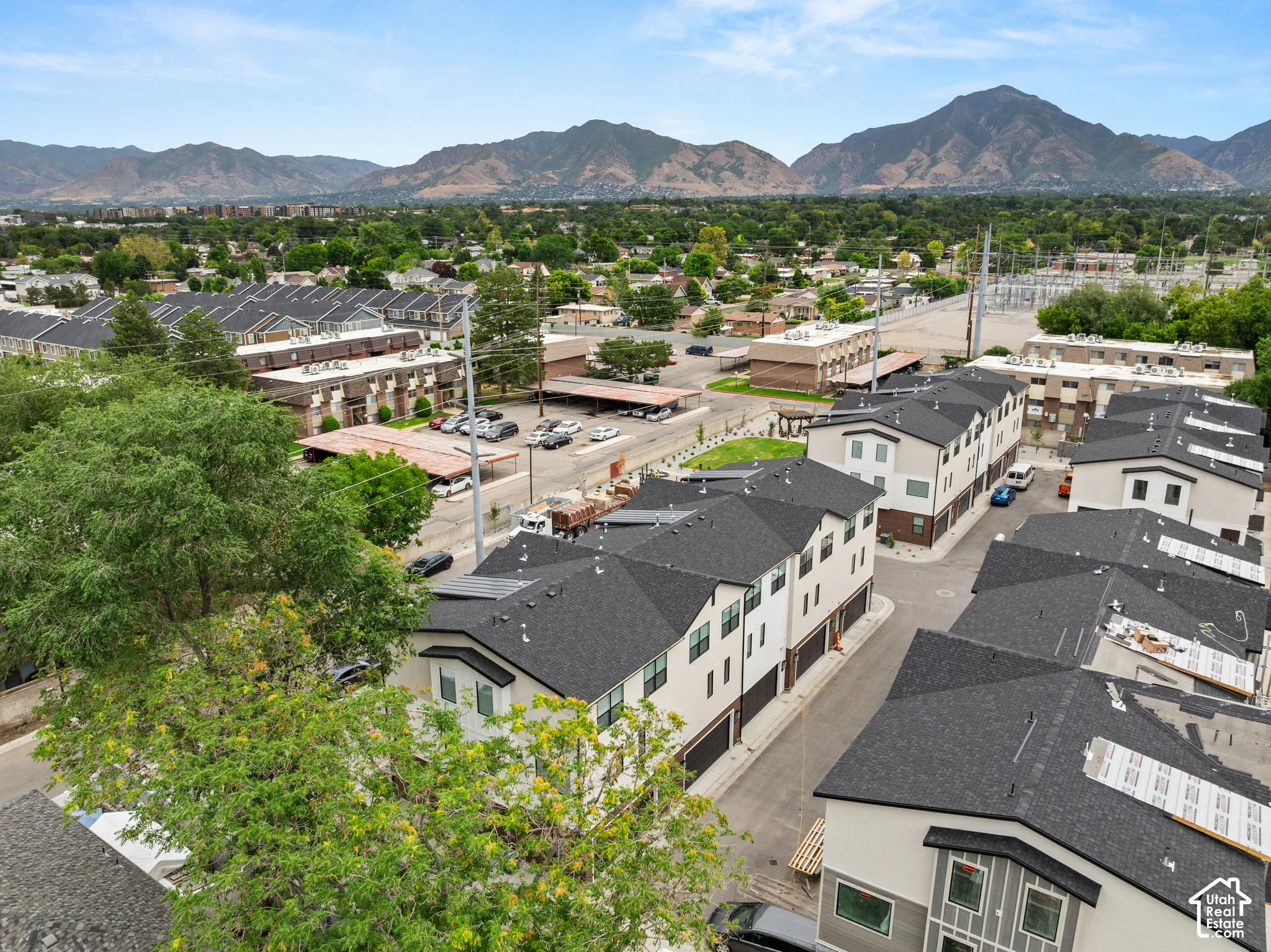 Multiple modern townhomes with dark shingle roofs, light-colored facades, and integrated garages