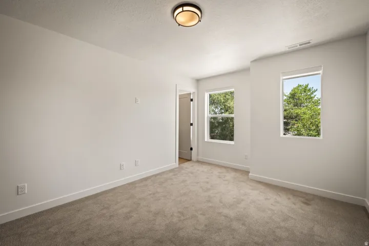 Carpeted room featuring multiple windows, recessed lighting, and white trim