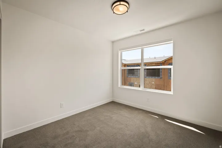 Wall-to-wall carpeting, white walls, and a multi-pane window
