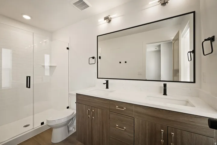 Frameless glass shower enclosure with white subway tile