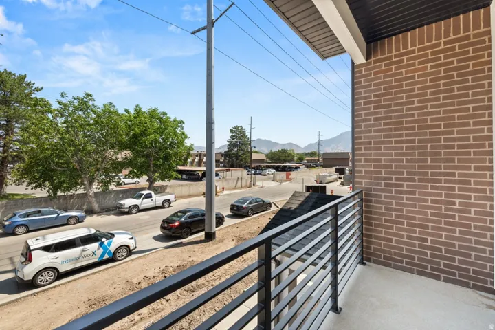 Private balcony with a metal horizontal slat railing and a brick exterior wall