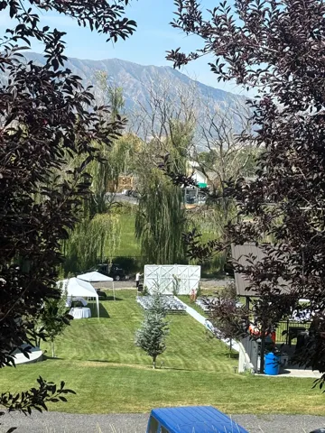 Manicured lawn with mature trees and a mountain backdrop