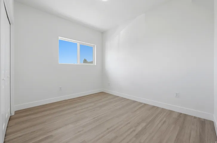 White walls, wood-finish flooring, and white trim
