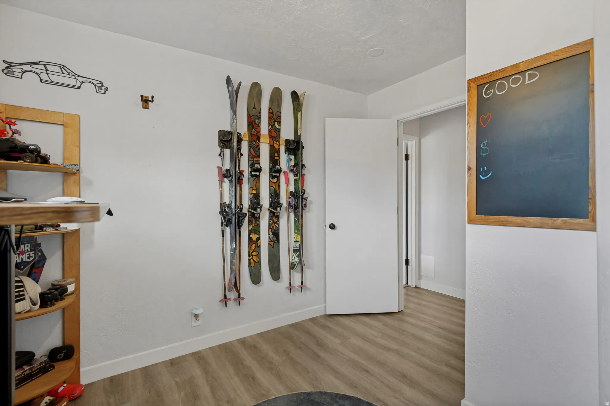 Light wood-finish flooring with white baseboards and a white painted wall finish