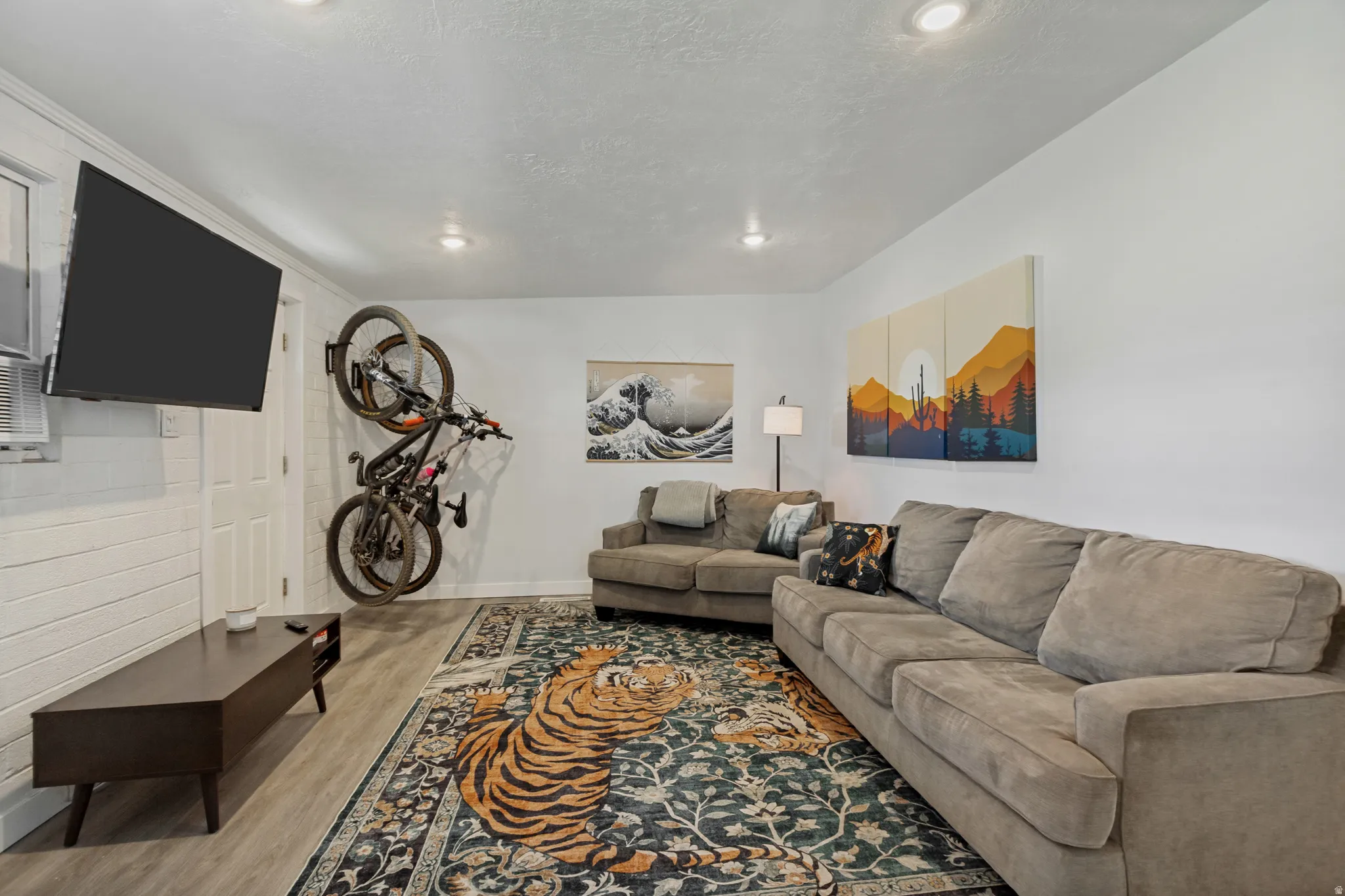 Recessed ceiling lighting, wood-finish flooring, white painted walls, and a white paneled door