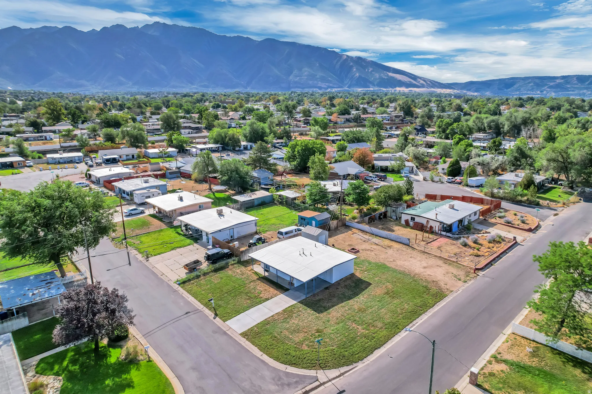 Mountain backdrop, residential neighborhood setting, streetside access, corner property, adjacent green space