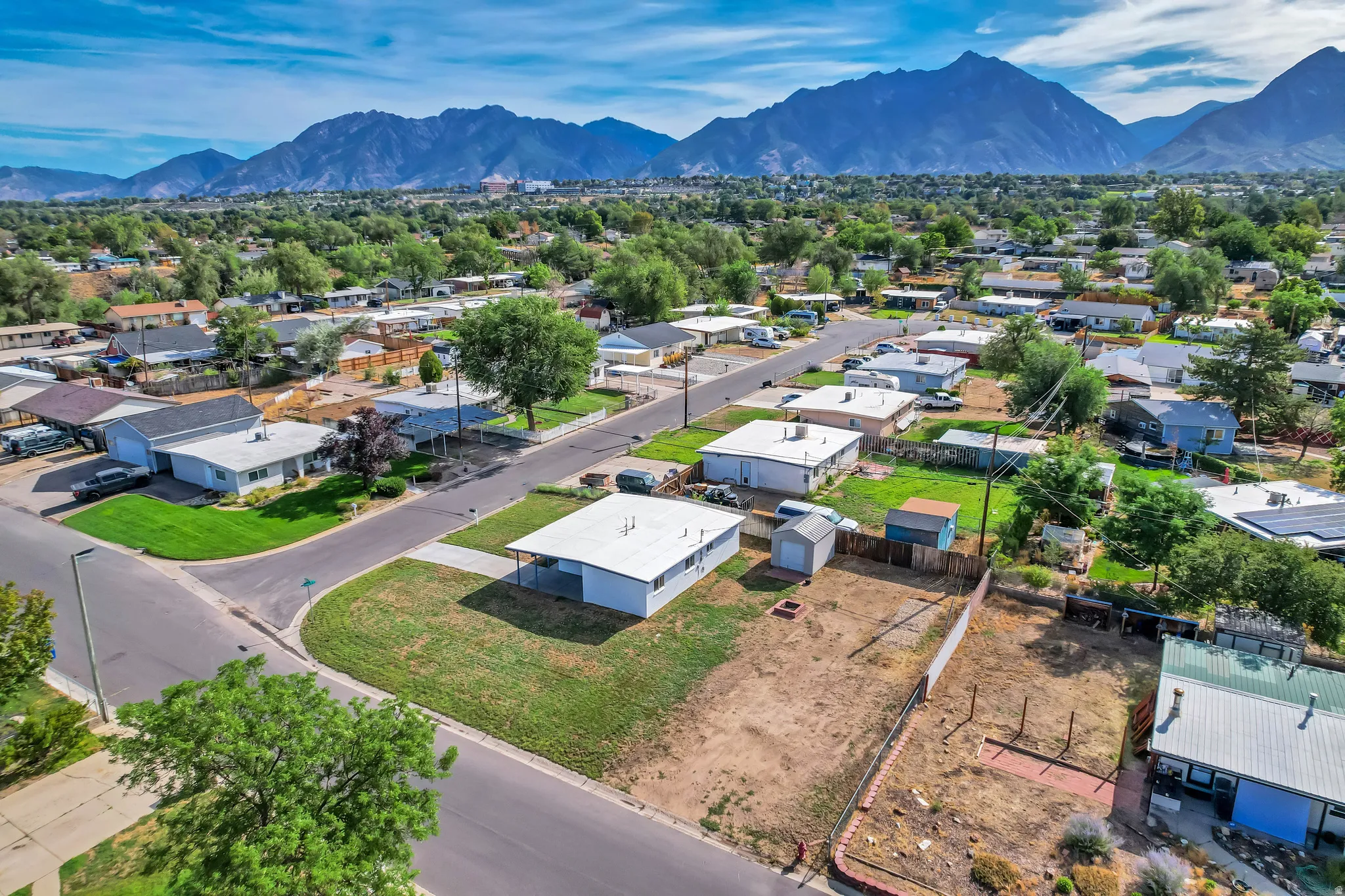 Mountain backdrop, residential neighborhood, paved streets, and established trees