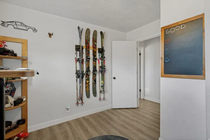 Light wood-finish flooring with white baseboards and a white painted wall finish