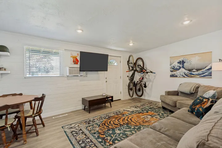Recessed lighting, wood-finish flooring, white shiplap wall, and a window with blinds