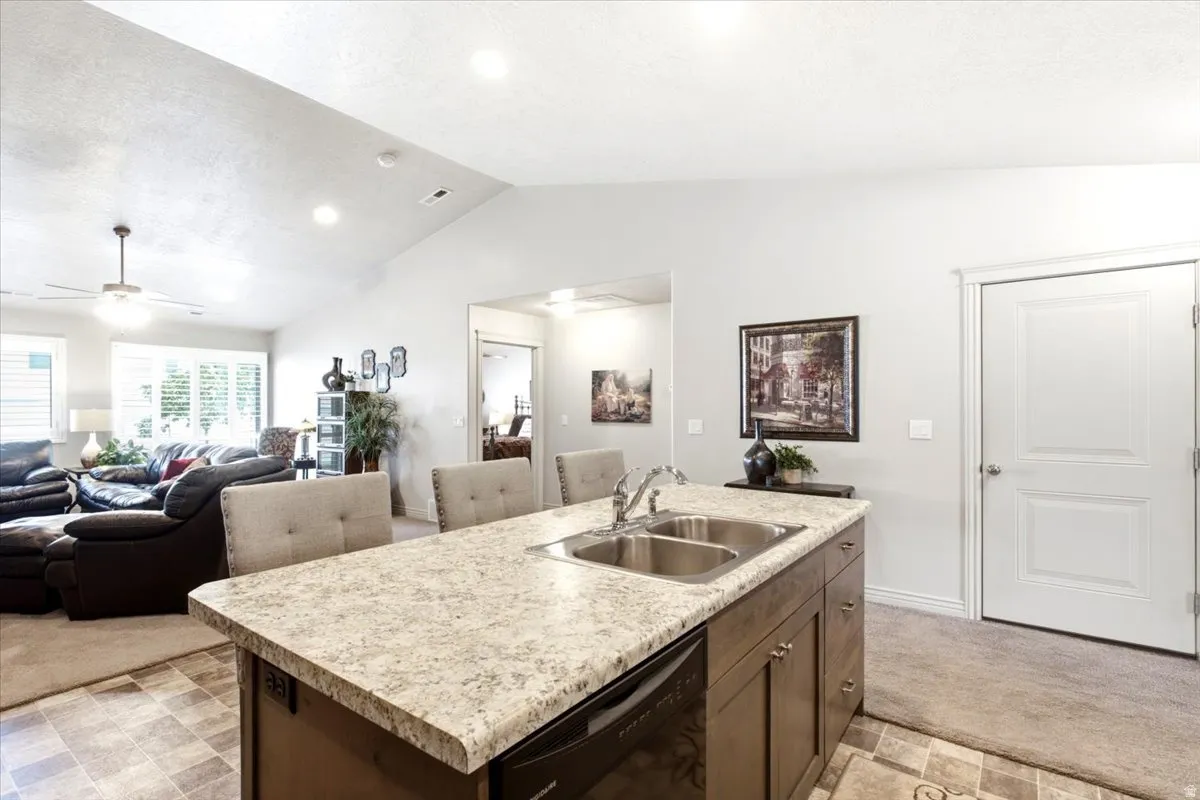 Kitchen island with dual stainless steel sink, integrated dishwasher, and seating for three