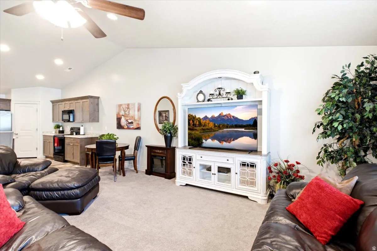 Vaulted ceilings with a ceiling fan, recessed lighting, and a kitchenette featuring wood-finish cabinetry and a built-in microwave