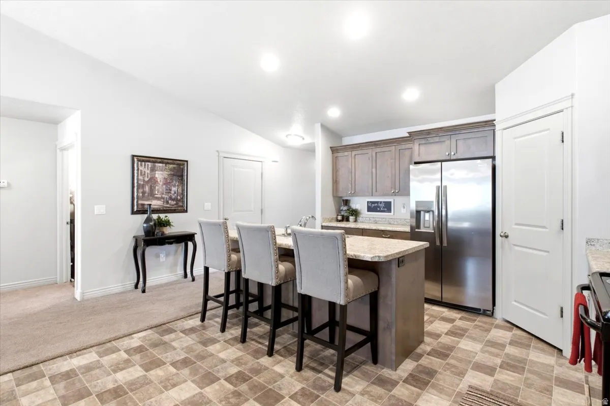 Kitchen with a central island, stainless steel refrigerator, and wood-finish cabinetry